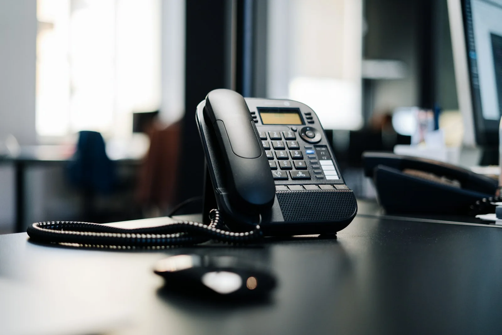 Black office desk phone on a table